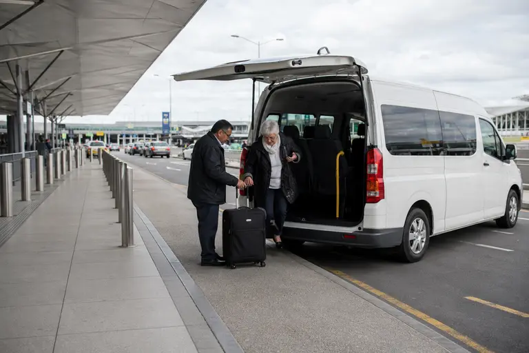 Melbourne Airport taxi transfer, driver helping passengers load luggage into the taxi van
